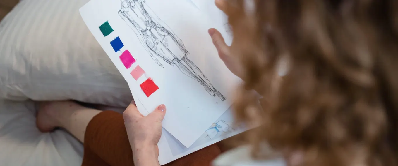 Gulvplan, fargeprøver og skisser samlet på et arbeidsbord under planlegging av et intervjusett.
